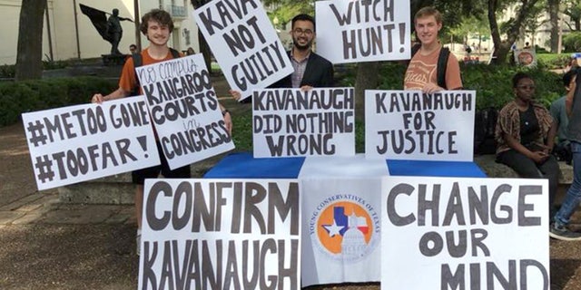 The Young Conservatives of Texas at the University of Texas, Austin hold up their signs before liberal students starting ripping up their signs and shouting expletives at them.