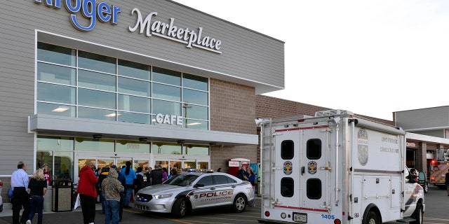 Employees wait outside the entrance of a Kroger grocery following a shooting that left two people dead and a suspect in custody, Wednesday, Oct. 24, 2018, in Jeffersontown, Ky. A man fatally shot another man inside a Kroger grocery store, shot and killed a woman in the parking lot, and then exchanged fire with an armed bystander who intervened before he fled the scene on the outskirts of Louisville, Kentucky, on Wednesday, police said. He was captured shortly afterward. (AP Photo/Timothy D. Easley)