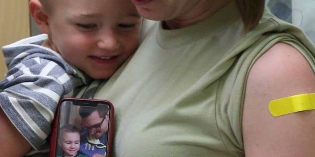 Laura Sidari, pictured holding one of her children and a photo of her husband with Leon, shortly after their second was born, is sharing the #FluShotsforLeon campaign after the boy died last year from complications of the virus.