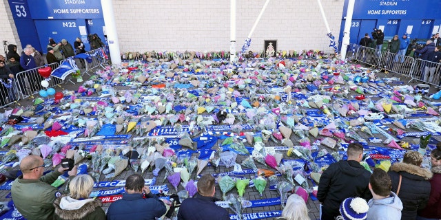 Supporters pay tribute outside Leicester City Football Club after a helicopter crashed in flames the day before, in Leicester, England, Sunday, Oct. 28, 2018. A helicopter belonging to Leicester City's owner, Thai billionaire Vichai Srivaddhanaprabha, crashed in flames in a car park next to the soccer club's stadium shortly after it took off from the field following a Premier League game on Saturday night. (Aaron Chown/PA via AP)