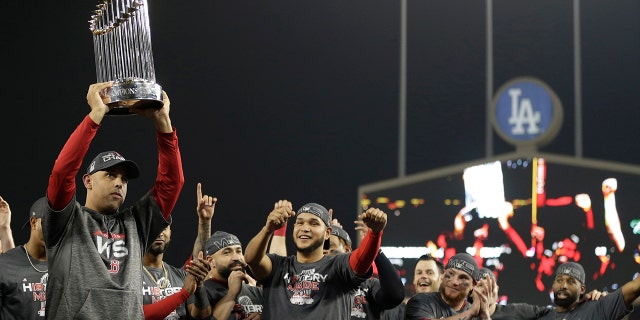 Boston Red Sox manager Alex Cora holds the championship trophy after Game 5 of baseball's World Series against the Los Angeles Dodgers on Sunday, Oct. 28, 2018, in Los Angeles..