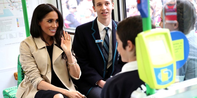 Meghan, Duchess of Sussex, talks to students while riding on a tram in Melbourne, Australia, Thursday, Oct. 18, 2018. Prince Harry and his wife Meghan are on day three of their 16-day tour of Australia and the South Pacific. (Chris Jackson/Pool Photo via AP)