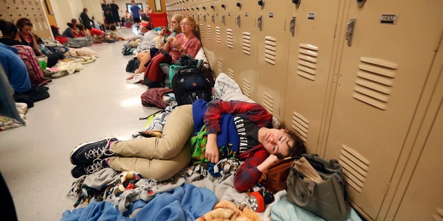 Emily Hindle lies on the floor at an evacuation shelter set up at Rutherford High School, in advance of Hurricane Michael.