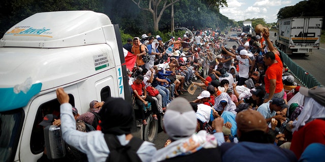 Central American migrants, who are part of a caravan of migrants trying to reach the United States, hitchhike on a truck along the highway as they continue their journey in Tapachula, Mexico. (REUTERS/Ueslei Marcelino)