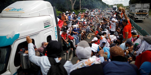 Central American migrants, who are part of a caravan of migrants trying to reach the United States, hitchhike on a truck along the highway as they continued their journey in Tapachula, Mexico, earlier this week.