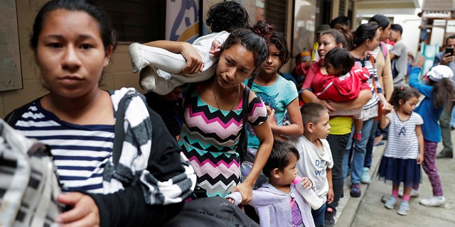 Honduran migrants, part of a caravan trying to reach the U.S., line up to enter a migrant shelter in Guatemala City, Guatemala Oct. 17, 2018. REUTERS/Luis Echeverria