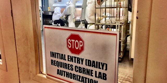 Department of Defense employees inside the Pentagon's mail screening facility inspect envelopes and packages, one step in the Pentagon's mail screening process, before the items are released to their addressees.