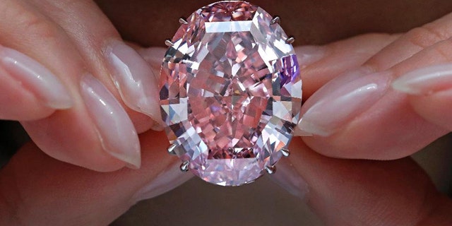 The "Pink Star" diamond, the most valuable cut diamond ever offered at auction, is displayed by a model at a Sotheby's auction room in Hong Kong.