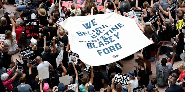 Capitol Hill Police form a line around protesters gathered in the atrium of the Hart Senate Office Building on Capitol Hill, Thursday, Oct. 4, 2018 in Washington.