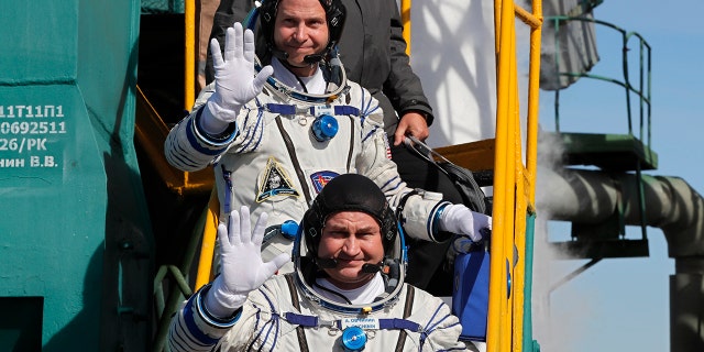 U.S. astronaut Nick Hague, top, and Russian cosmonaut Alexey Ovchinin, crew members of the mission to the International Space Station wave as they board the rocket prior to the launch of Soyuz-FG rocket at the Russian leased Baikonur cosmodrome, Kazakhstan, Thursday, Oct. 11, 2018.