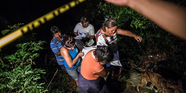 Relatives of a Mara Salvatrucha gang member retrieve his body from a steep gully after he was shot dead in a confrontation with police, in Olocuilta, El Salvador. Two bodies were found at the bottom of the gully following a shootout that began near an old cattle stable, which gang members had turned into a shooting range. El Salvador’s homicide rate was 60 per 100,000 inhabitants last year, down from a grisly record of 102 homicides per 100,000 inhabitants in 2015 but still among the highest in the world. (AP Photo/Manu Brabo, File)