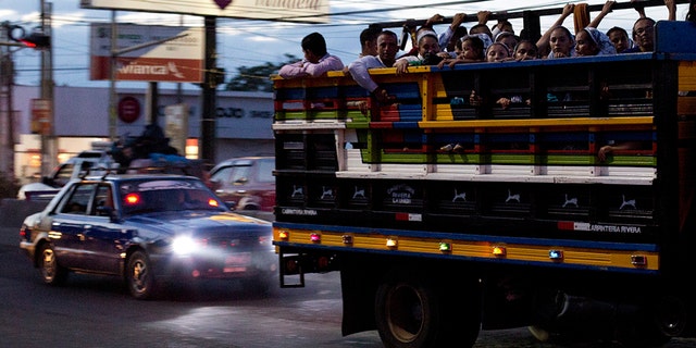 Commuters ride in the back of a pickup as night falls in San Miguel, El Salvador. It’s a small country both geographically and by population, home to 6.5 million inhabitants. The International Organization for Migration estimates that another 1.35 million Salvadorans live in the United States. (AP Photo/Rebecca Blackwell, File)