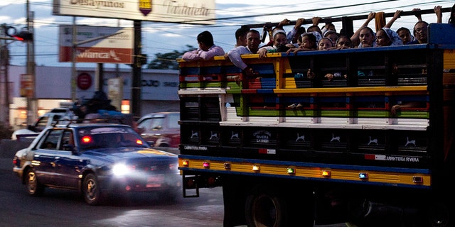 Commuters ride in the back of a pickup as night falls in San Miguel, El Salvador. It’s a small country both geographically and by population, home to 6.5 million inhabitants. The International Organization for Migration estimates that another 1.35 million Salvadorans live in the United States. (AP Photo/Rebecca Blackwell, File)