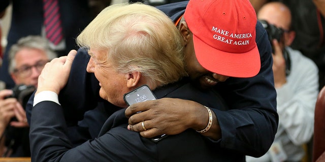 President Donald Trump hugs rapper Kanye West during a meeting in the Oval office of the White House on October 11, 2018.