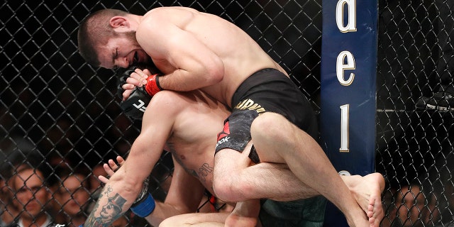 Khabib Nurmagomedov, top, applies a rear naked choke hold to Conor McGregor during a lightweight title mixed martial arts bout at UFC 229 in Las Vegas, Saturday, Oct. 6, 2018. Nurmagomedov won the fight by submission during the fourth round to retain the title. (AP Photo/John Locher)