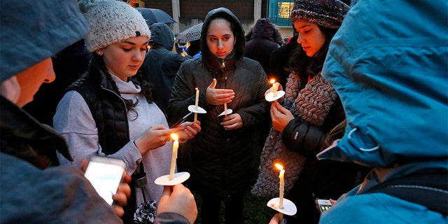 Holding candles, a group of girls wait for the start of a memorial vigil at the intersection of Murray Ave. and Forbes Ave. in the Squirrel Hill section of Pittsburgh, for the victims of the shooting at the Tree of Life Synagogue where a shooter opened fire, killing multiple people and wounding others, including sevearl police officers.