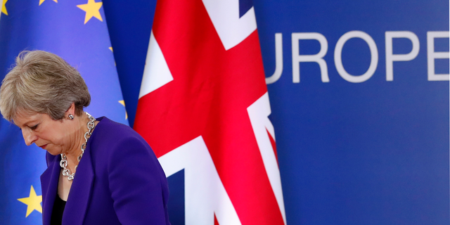 British Prime Minister Theresa May walks off the podium after a media conference during an EU summit in Brussels, Thursday, Oct. 18, 2018. EU leaders met for a second day on Thursday to discuss migration, cybersecurity and to try and move ahead on stalled Brexit talks. (AP Photo/Alastair Grant)