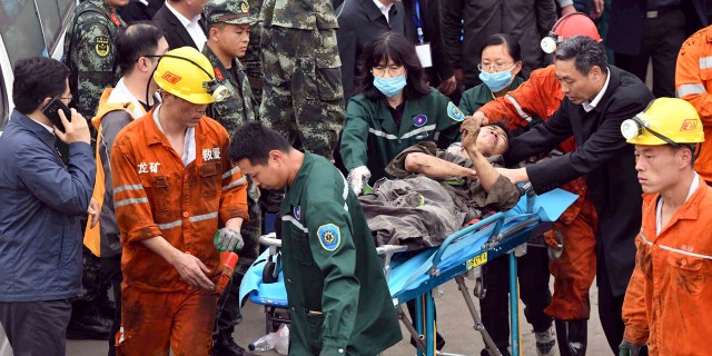 In this photo released by China's Xinhua News Agency, a worker is carried on a stretcher out of the Longyun coal mine in Yuncheng County, east China's Shandong Province, Sunday, Oct. 21, 2018.