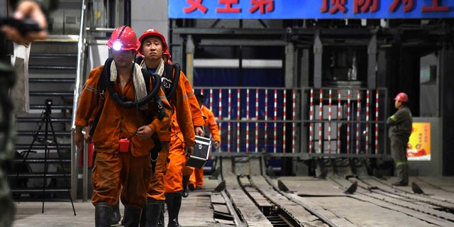 In this photo taken Oct. 21, 2018 and released by Xinhua News Agency, rescuers walk out of the site of a coal mine where falling rocks killed miners and trapped some in Yuncheng County in eastern China's Shandong Province.