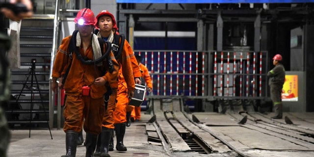 In this photo taken Oct. 21, 2018 and released by Xinhua News Agency, rescuers walk out of the site of a coal mine where falling rocks killed miners and trapped some in Yuncheng County in eastern China's Shandong Province.