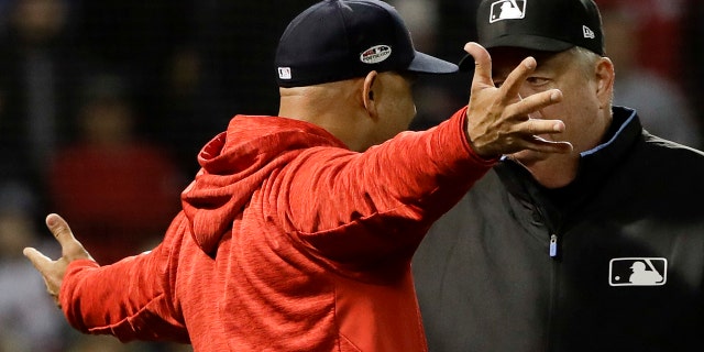 Boston Red Sox manager Alex Cora argues a strike three call with umpire Joe West during the fifth inning in Game 1 of a baseball American League Championship Series against the Houston Astros on Saturday, Oct. 13, 2018, in Boston.