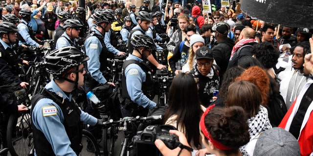 Protesters stand near police in downtown after a jury said Chicago police officer, Jason Van Dyke, guilty of second degree murder, during the Laquan McDonald shootout , black teenager, on Friday, October 5, 2018 in Chicago. 