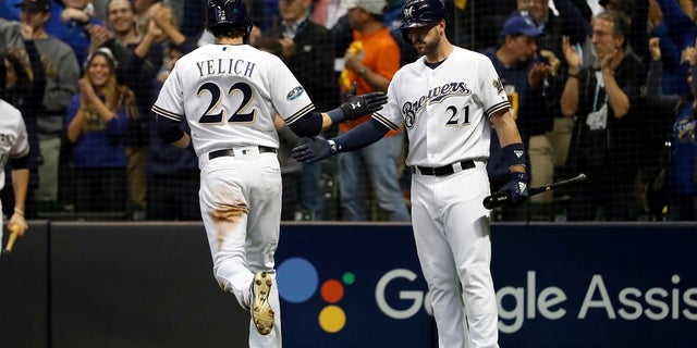 File - Milwaukee Brewers' Christian Yelich (22) celebrates with Travis Shaw (21) after scoring a run during the second inning of Game 6 of the National League Championship Series baseball game against the Los Angeles Dodgers Friday.