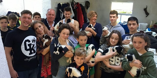 A litter of 14 pups orphaned when their mother died giving birth have been saved after they were hand reared - by an entire village.