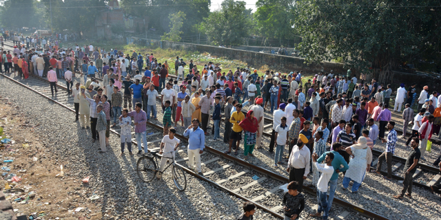 A crowd gathers at the site of Friday's train accident in Amritsar, India, Saturday, Oct. 20, 2018. A speeding train ran over a crowd watching fireworks during a religious festival in northern India on Friday evening, killing more than 50 people and injuring dozens more, police said.