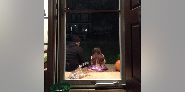 The author's husband photographed sitting next to their daughter.
