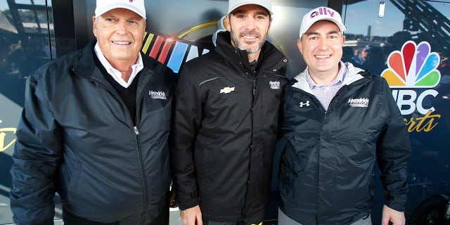 Jimmie Johnson, center, poses with owner Rick Hendrick, left, and Ally Financial CEO Jeffery Brown, right.