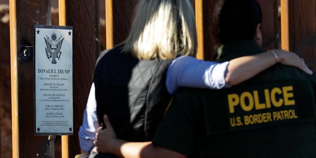 U.S. Department of Homeland Security Secretary Kirstjen Nielsen, center, embraces Gloria Chavez, Border Patrol chief of the El Centro sector, as the look at a plaque adorning a newly fortified border wall structure Friday.