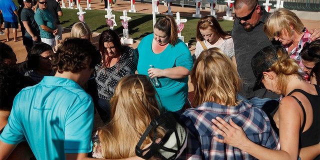 People pray at a makeshift memorial for victims of the Las Vegas shooting Sunday in Las Vegas.