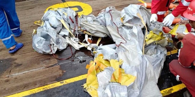 In this photo released by Indonesian Disaster Mitigation Agency (BNPB) rescuers inspect debris believed to be from Lion Air passenger jet that crashed off West Java on Monday, Oct. 29, 2018.
