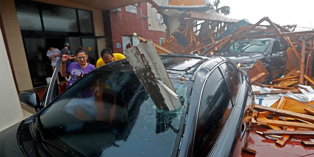 A woman checks on her vehicle as Hurricane Michael passes through, after the hotel canopy had just collapsed, in Panama City Beach on Wednesday.