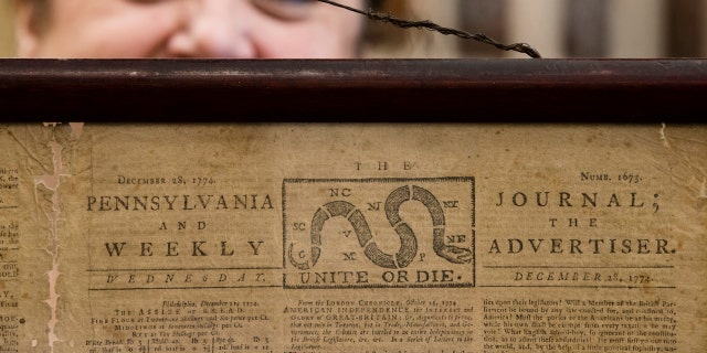 Heather Randall displays a Dec. 28, 1774, Pennsylvania Journal and the Weekly Advertiser at the Goodwill Industries in Bellmawr, N.J., Thursday.