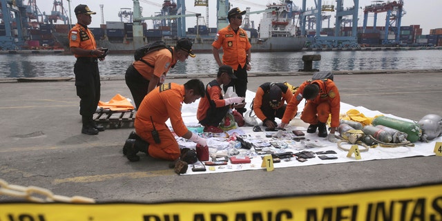 Rescuers examine personal belongings of passengers of a crashed Lion Air plane recovered from the waters near where the passenger jet is believed to have crashed, at Tanjung Priok Port in Jakarta, Indonesia, Tuesday, Oct. 30, 2018.