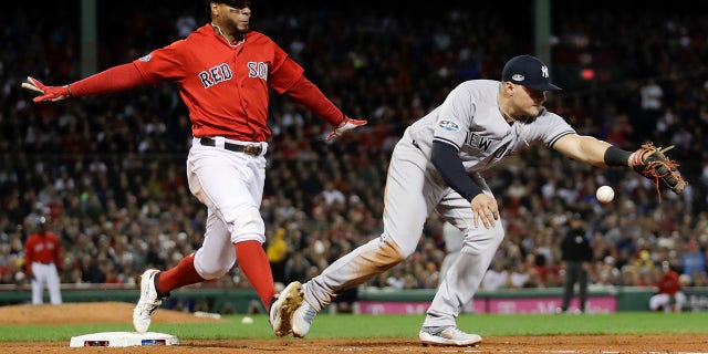 New York Yankees first baseman Luke Voit, right, fails to hang on to the throw after a single by Boston Red Sox's Xander Bogaerts during the fifth inning of Game 1 of the American League Division Series, in Boston, Oct. 5, 2018.
