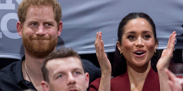 Britain's Prince Harry and Meghan, Duchess of Sussex applaud as they watch the wheelchair basketball final at The Invictus Games in Sydney, Australia, Saturday, Oct. 27, 2018. Prince Harry and his wife Meghan are on day twelve of their 16-day tour of Australia and the South Pacific. (AP Photo)