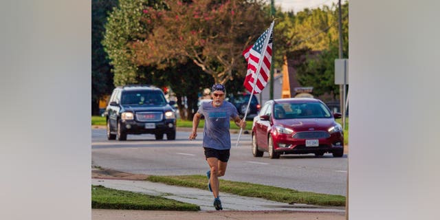 Virginia man Wayne Parfitt runs with the flag in hand to honor his son, who is deployed overseas.