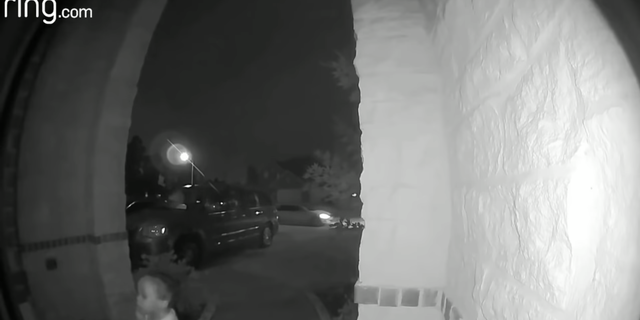 The toddler is seen standing at the door as the woman drives away in her white car. (Montgomery County Sheriff's Office)