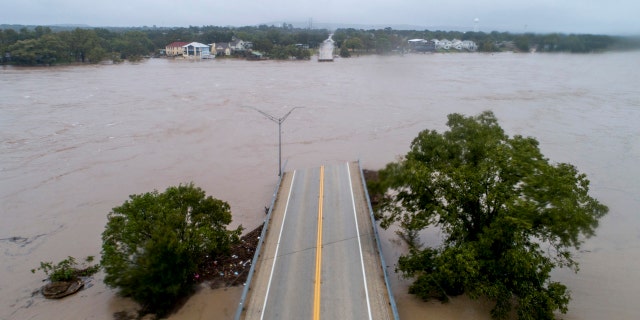 The Llano River flows between the washed out Ranch Road 2900 bridge in Kingsland, Texas.