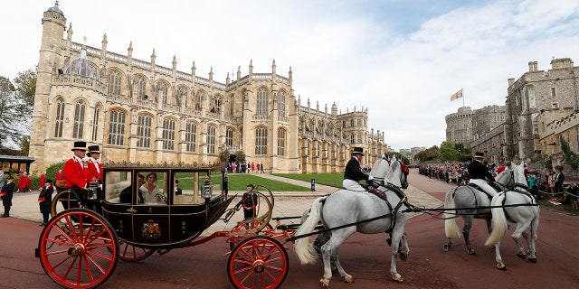 Britain's Princess Eugenie of York, right, and her husband Jack Brooksban travel in the Scottish State Coach following their wedding at St George’s Chapel, Windsor Castle, near London, England, Friday Oct. 12, 2018. (Adrian Dennis/Pool via AP)