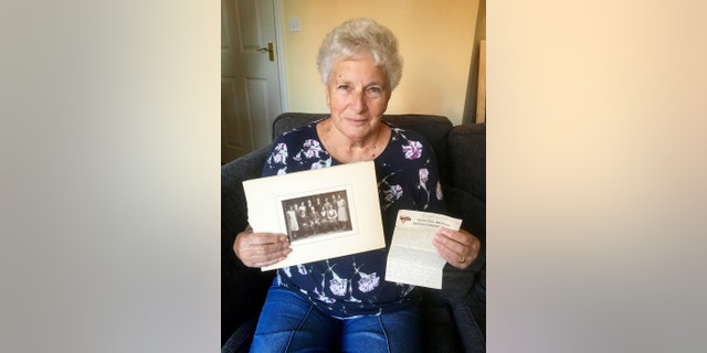 Christine Spall, with the letter and family photograph. (Credit: SWNS)