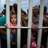 Migrants bound for the United States-Mexico border wait on a bridge that stretches over the Suchiate River, connecting Guatemala and Mexico, in Tecun Uman, Guatemala, on Oct. 19, 2018.