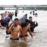 Central American migrants, part of a caravan trying to reach the United States cross the Suchiate River in Ciudad Hidalgo, Mexico, on Oct. 20, 2018.