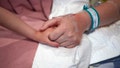 Female caucasian hospital patient holding a preschool age girl's hand.