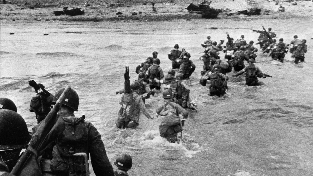 File photo - American troops supporting those already on the coast of Northern France, plunge into the surf and wade shoreward carrying equipment, on Utah Beach, Les Dunes de Madeleine, France.