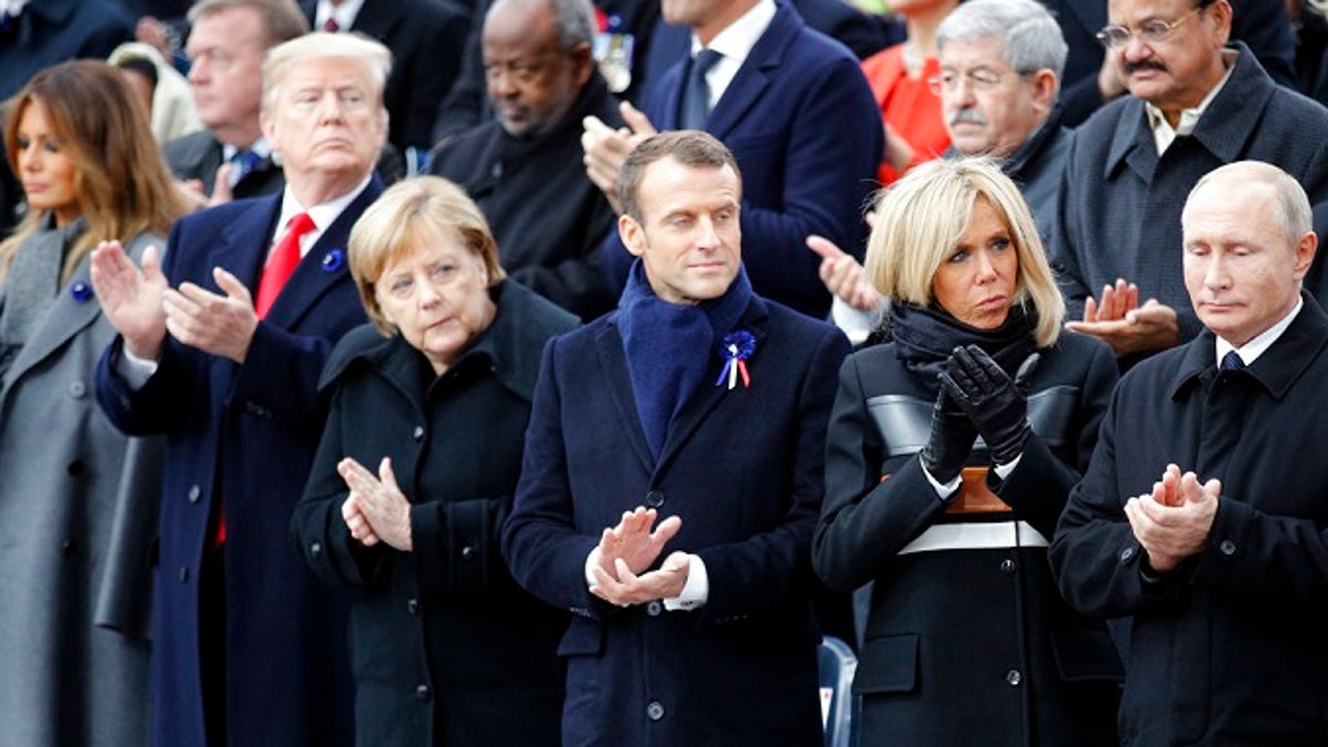 U.S President Donald Trump, second left, and first lady Melania Trump, left, German Chancellor Angela Merkel, third left, French President Emmanuel Macron and his wife Brigitte, Russian President Vladimir Putin, right, applaud after ceremonies at the Arc de Triomphe Sunday, Nov. 11, 2018 in Paris. Over 60 heads of state and government were taking part in a solemn ceremony at the Tomb of the Unknown Soldier, the mute and powerful symbol of sacrifice to the millions who died from 1914-18. (AP Photo/Francois Mori, Pool)
