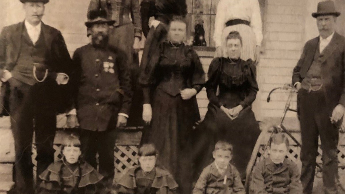 Maker would often write home to his family during World War I. He is pictured here as a young boy, on the far right of the bottom row. To his side, from right to left, are his stepsister Harriet, sister Eva and brother Clifford (Kip). His uncle Edward, wearing a Union Army uniform, is second from the left in the middle row, next to Edward's brother, Andrew. Both of those men fought for 19th Maine Regiment during the Civil War. Maker's father, Winfield, is standing in front of the bicycle on the far right.